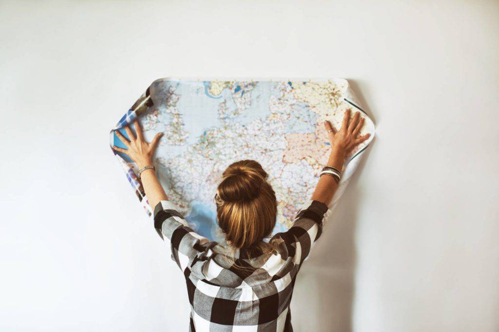 someone holding up a map of the world