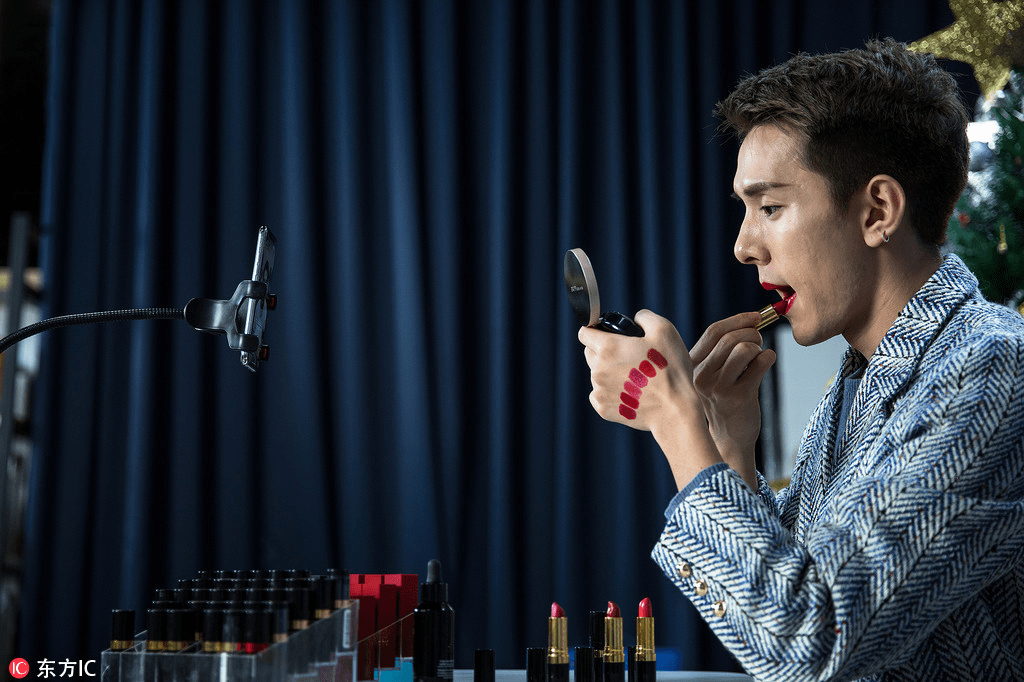 Image showing a man trying out different shades of lipstick.