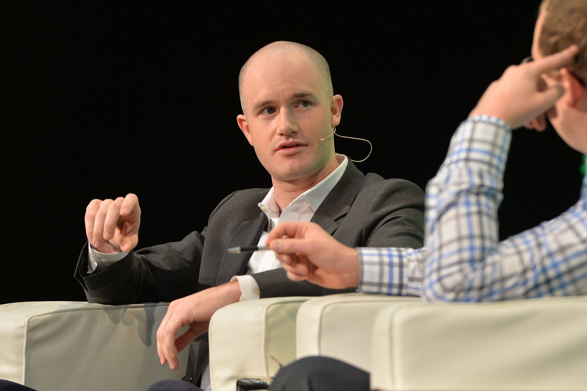 Coinbase CEO and co-founder Brian Armstrong sitting in a chair