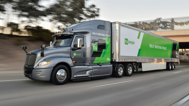 A semi truck hauling a trailer with the TuSimple logo